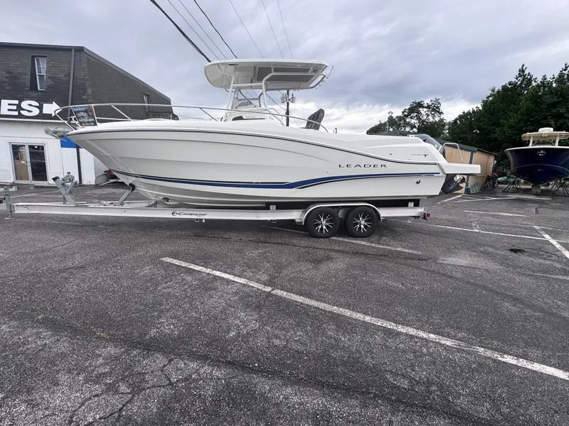 Slide: The Image of 2020 Jeanneau Leader 9.0 CC boat on trailer in parking lot, overcast sky. - 2