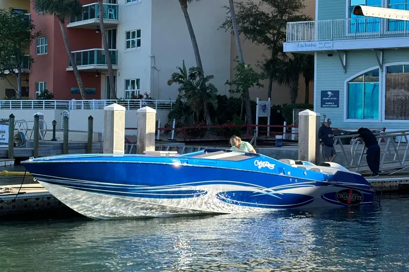 The Image of 1989 Cigarette 35 Cafe Racer boat docked, featuring sleek blue and white design. - 0