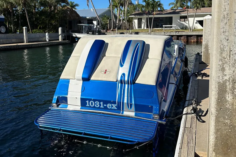 Slide: The Image of 1989 Cigarette 35 Cafe Racer boat docked, featuring blue and white design. - 4