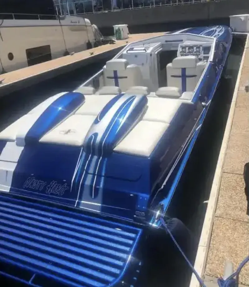 Slide: The Image of 1989 Cigarette 35 Cafe Racer boat with blue and white design docked in a marina. - 9