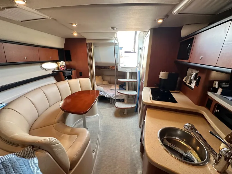 Slide: The Image of 2004 Chaparral Signature 310 interior with cozy seating, kitchenette, and sleeping area. - 10
