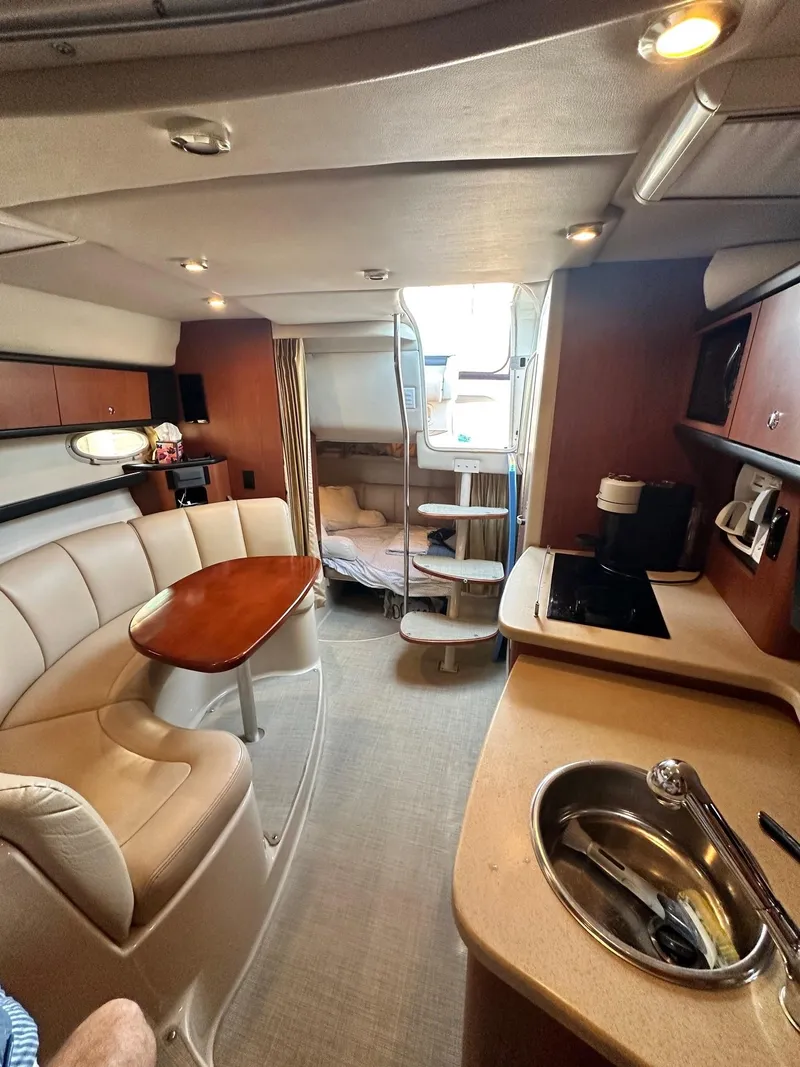Slide: The Image of 2004 Chaparral Signature 310 cabin interior with seating, kitchenette, and sleeping area. - 11