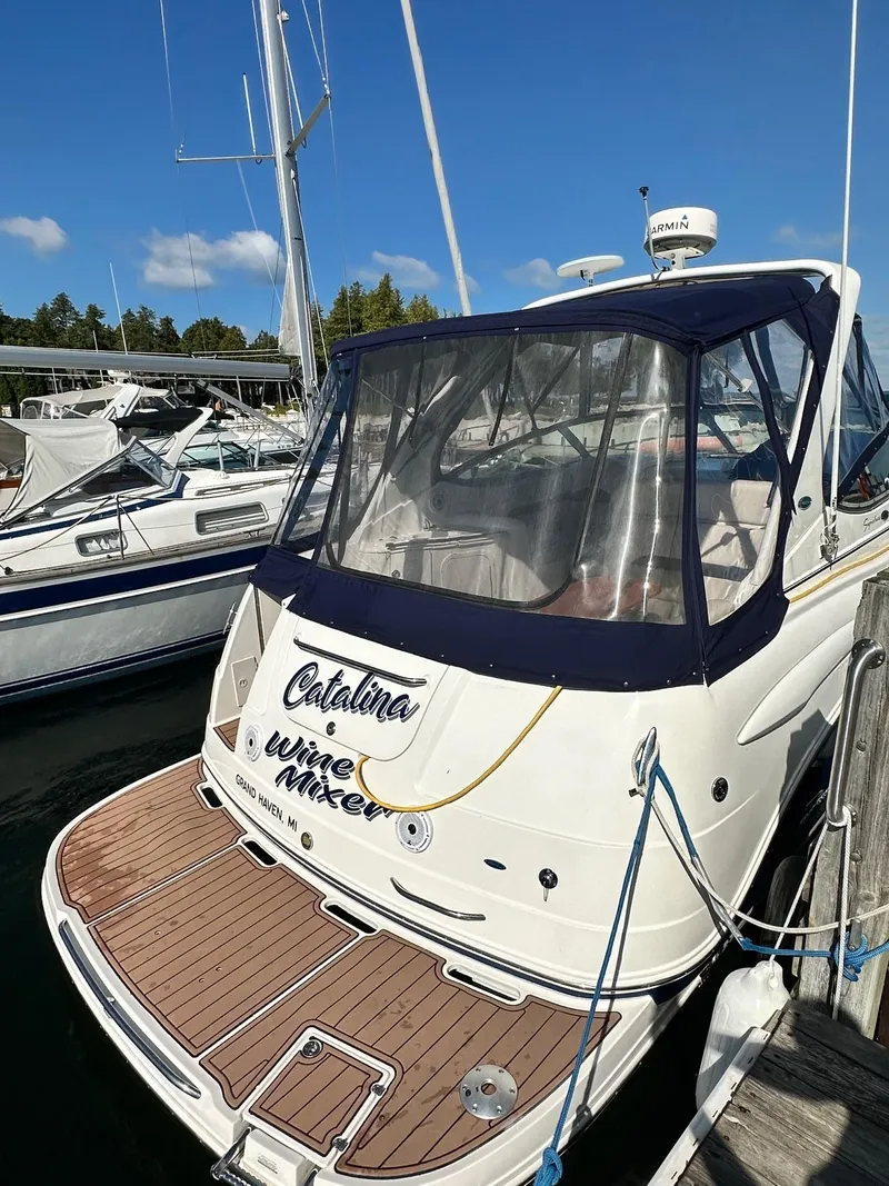 Slide: The Image of 2004 Chaparral Signature 310 boat docked, featuring a sleek design and spacious deck. - 2