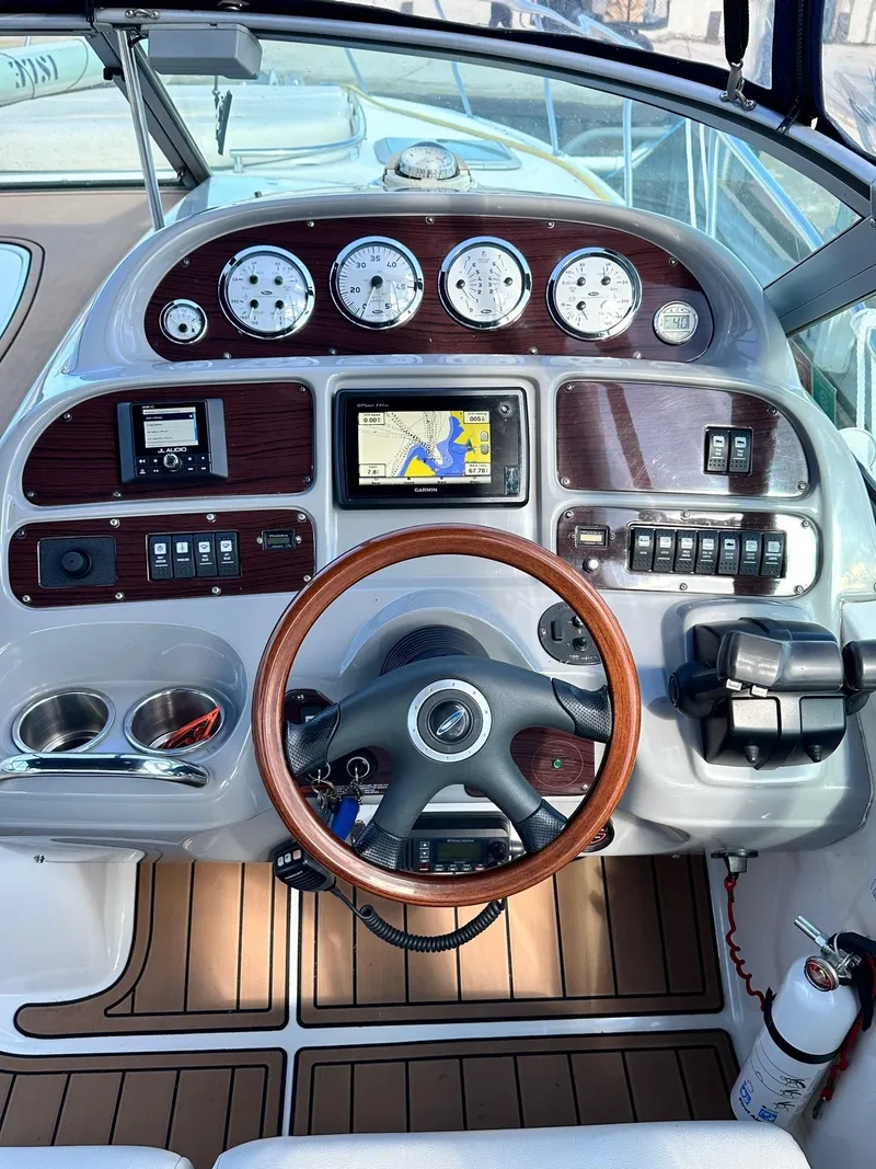 Slide: The Image of 2004 Chaparral Signature 310 boat dashboard with wooden steering wheel and navigation system. - 6