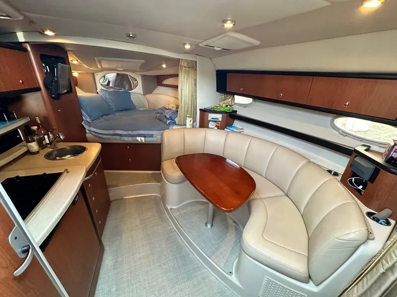 Slide: The Image of 2004 Chaparral Signature 310 interior with cozy seating, kitchenette, and sleeping area. - 7
