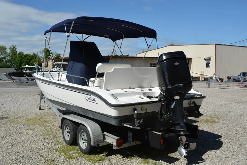 Slide: The Image of 2006 Boston Whaler 220 Dauntless boat on trailer, featuring outboard motor and canopy. - 4