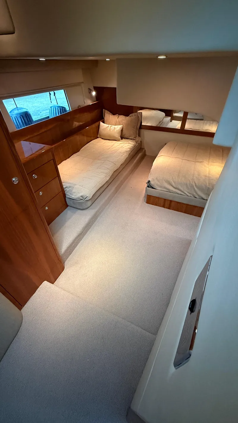 Slide: The Image of 2011 Riviera 43 IPS Open Flybridge cabin with twin beds and wooden cabinetry. - 13