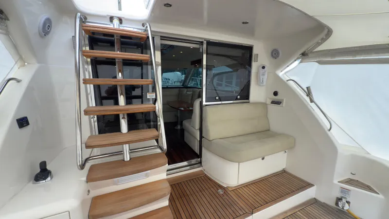 Slide: The Image of 2011 Riviera 43 IPS Open Flybridge with wooden steps and cushioned seating area. - 14