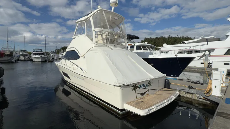 Slide: The Image of 2011 Riviera 43 IPS Open Flybridge yacht docked at marina under cloudy sky. - 23