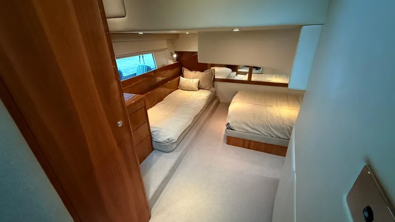 Slide: The Image of Luxurious 2011 Riviera 43 IPS Open Flybridge cabin with twin beds and wooden furnishings. - 12