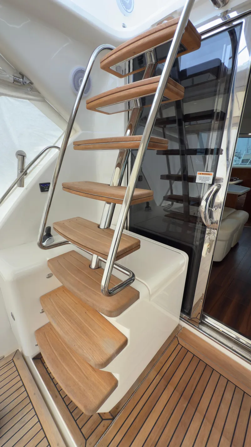 Slide: The Image of Staircase on 2011 Riviera 43 IPS Open Flybridge yacht with wooden steps and metal railing. - 15