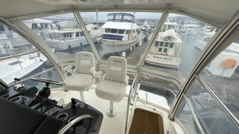 Slide: The Image of Interior view of 2011 Riviera 43 IPS Open Flybridge, showcasing helm and marina backdrop. - 17