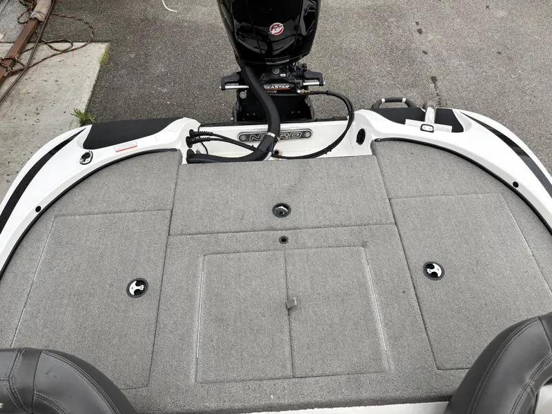 Slide: The Image of 2017 Nitro Z18 boat deck with motor, featuring gray carpet and storage compartments. - 11