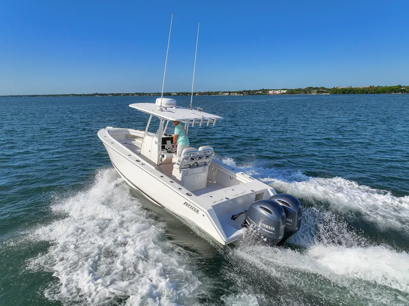 Slide: The Image of 2018 Jupiter 26 FS boat cruising on open water with twin engines. - 18