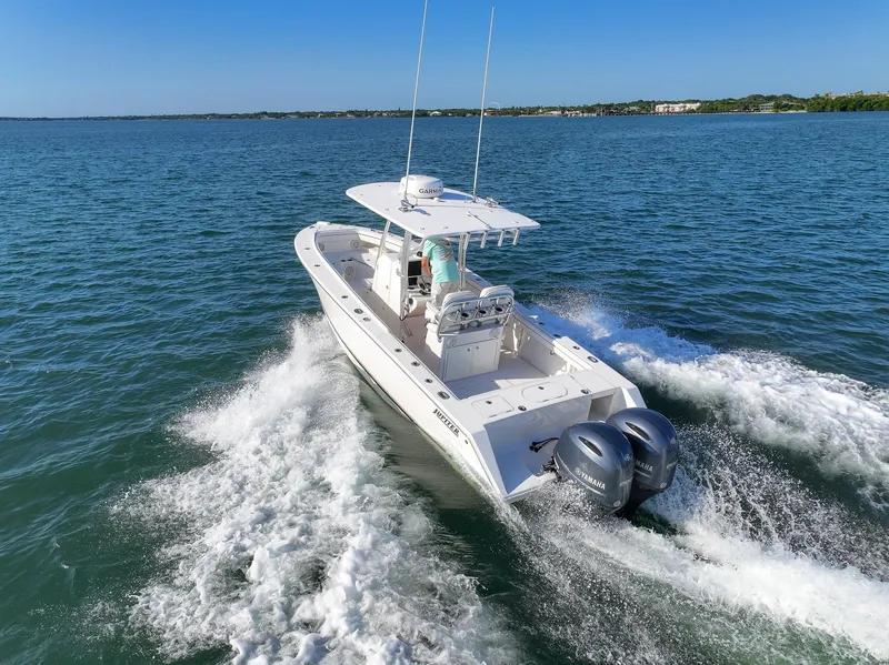 Slide: The Image of 2018 Jupiter 26 FS boat cruising on open water with twin engines. - 19