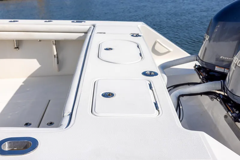 Slide: The Image of 2018 Jupiter 26 FS boat deck with storage compartments and dual engines. - 26