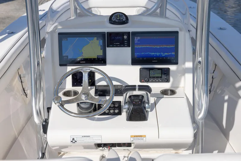 Slide: The Image of 2018 Jupiter 26 FS boat console with dual navigation screens and steering wheel. - 28