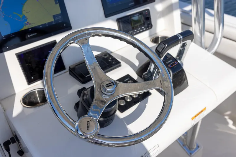 Slide: The Image of Steering wheel and controls of a 2018 Jupiter 26 FS boat cockpit. - 31