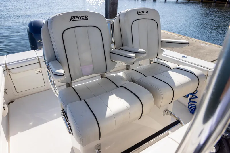 Slide: The Image of 2018 Jupiter 26 FS boat seats, white with black trim, docked by the water. - 35