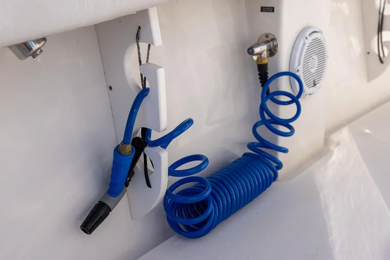 Slide: The Image of Blue coiled hose and nozzle on 2018 Jupiter 26 FS boat deck. - 37