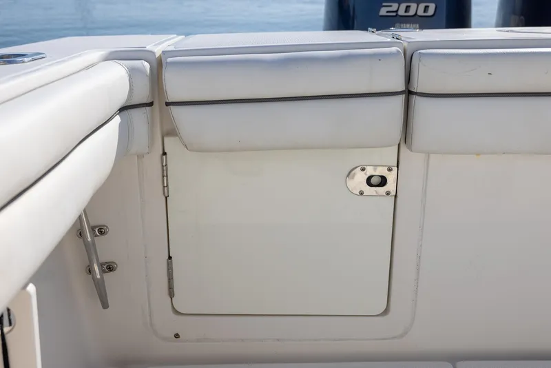Slide: The Image of 2018 Jupiter 26 FS boat interior with white cushioned seating and storage compartment. - 46