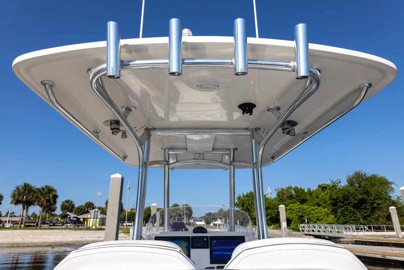 Slide: The Image of 2018 Jupiter 26 FS boat with T-top and rod holders, docked under clear blue sky. - 48