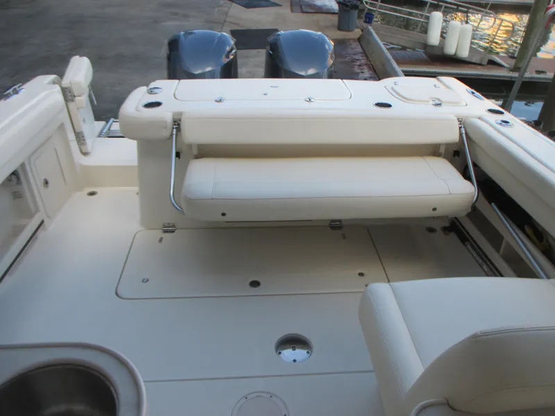Slide: The Image of 2018 Grady-White Freedom 307 boat interior with seating and dual engines at dock. - 17