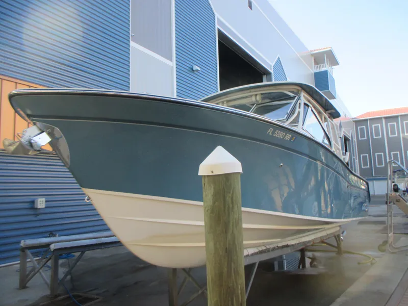 Slide: The Image of 2018 Grady-White Freedom 307 boat docked near a blue building. - 2