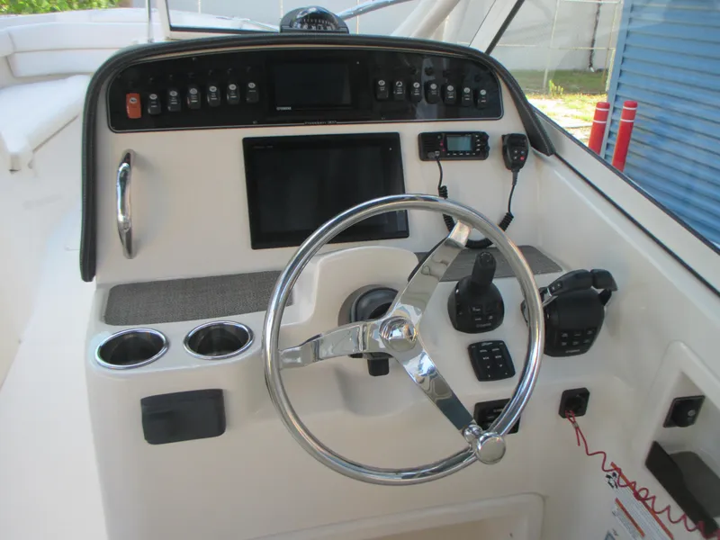 Slide: The Image of 2018 Grady-White Freedom 307 boat dashboard with steering wheel and control panel. - 24