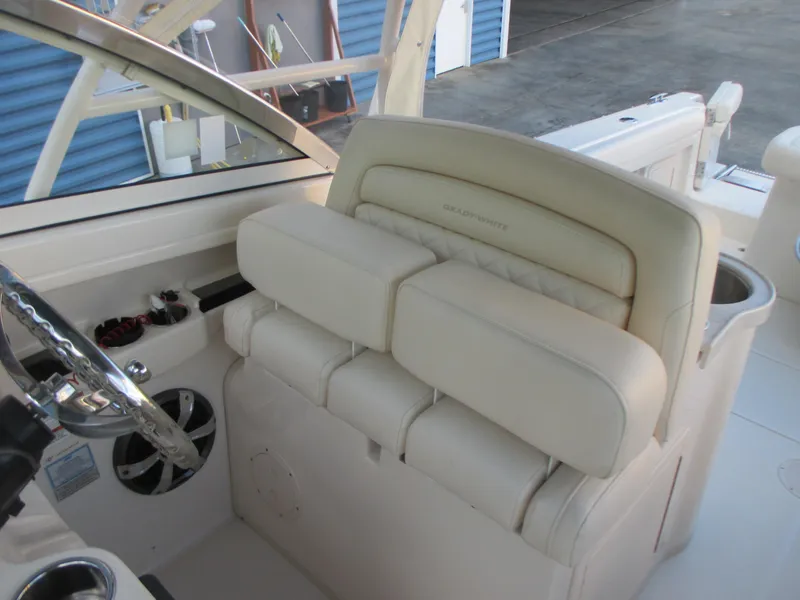 Slide: The Image of 2018 Grady-White Freedom 307 boat interior with beige seating and steering wheel. - 25