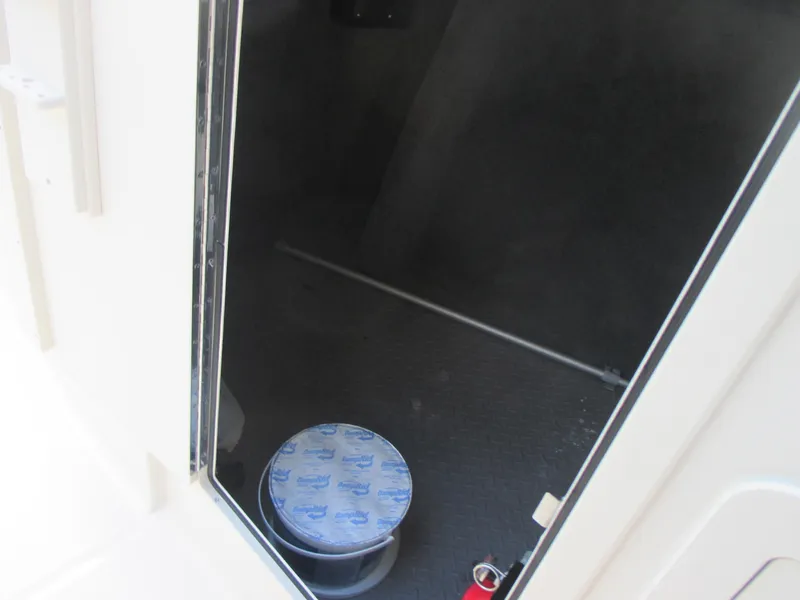 Slide: The Image of 2018 Grady-White Freedom 307 boat storage compartment with a sealed container inside. - 31