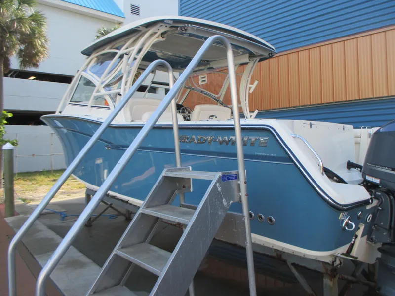Slide: The Image of 2018 Grady-White Freedom 307 boat in blue, docked with metal stairs. - 6