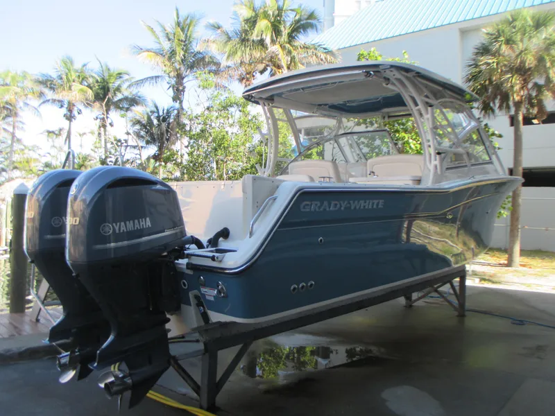 Slide: The Image of 2018 Grady-White Freedom 307 boat with Yamaha engines, docked near palm trees. - 7