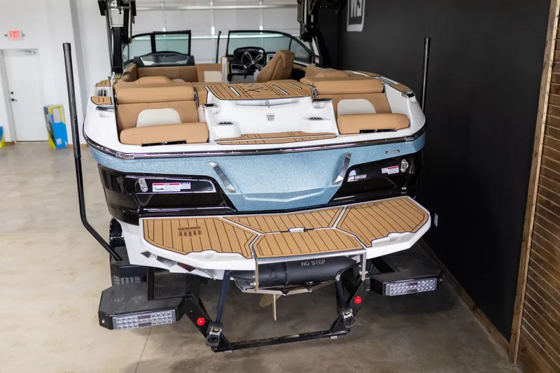 Slide: The Image of 2024 MasterCraft X24 boat with tan seating and teak swim platform in a showroom. - 6