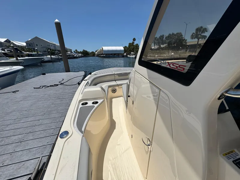 Slide: The Image of 2025 Scout 281 XSS boat docked by a scenic waterfront. - 14