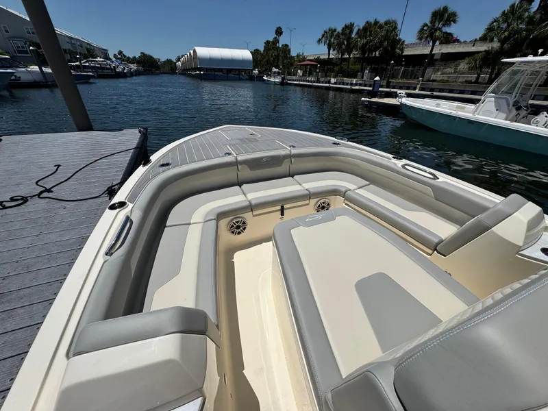 Slide: The Image of 2025 Scout 281 XSS boat interior with seating, docked by a marina. - 15