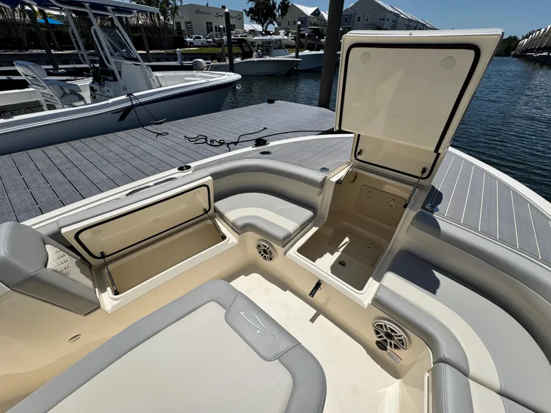 Slide: The Image of 2025 Scout 281 XSS boat with open storage compartments, docked by the water. - 16