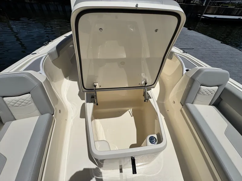 Slide: The Image of 2025 Scout 281 XSS boat with open storage compartment, featuring cushioned seating. - 18