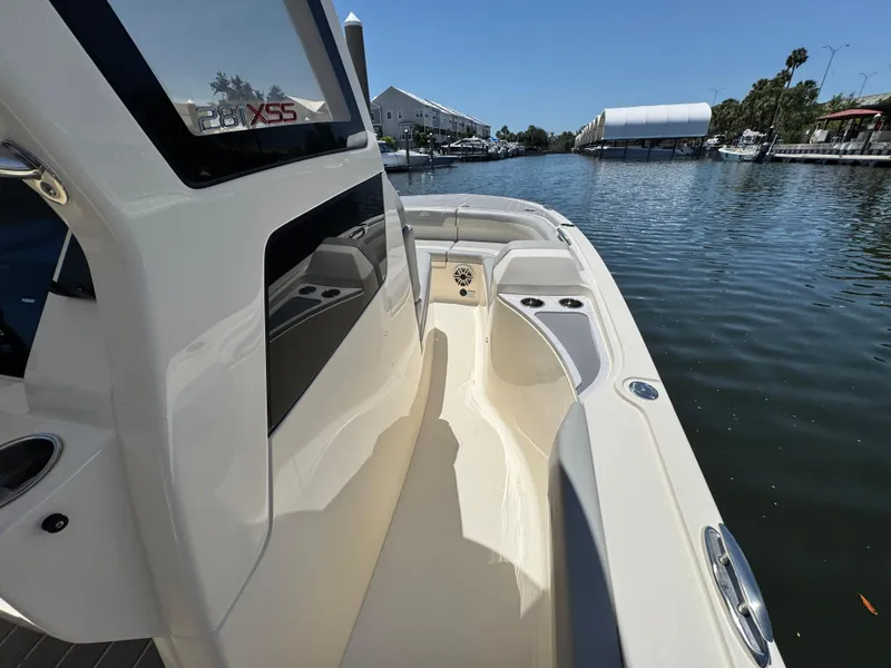 Slide: The Image of 2025 Scout 281 XSS boat on a calm waterway, showcasing sleek design and spacious deck. - 19