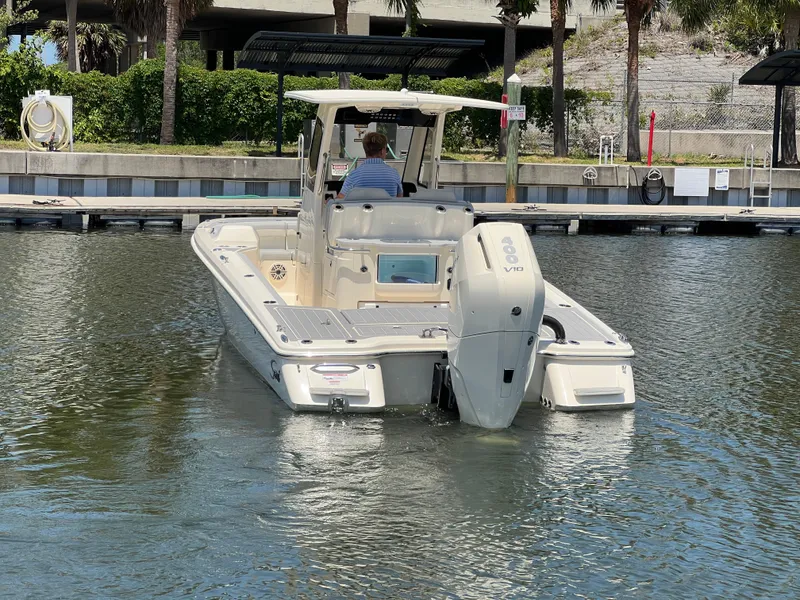 Slide: The Image of 2025 Scout 281 XSS boat docked in a marina, rear view. - 2