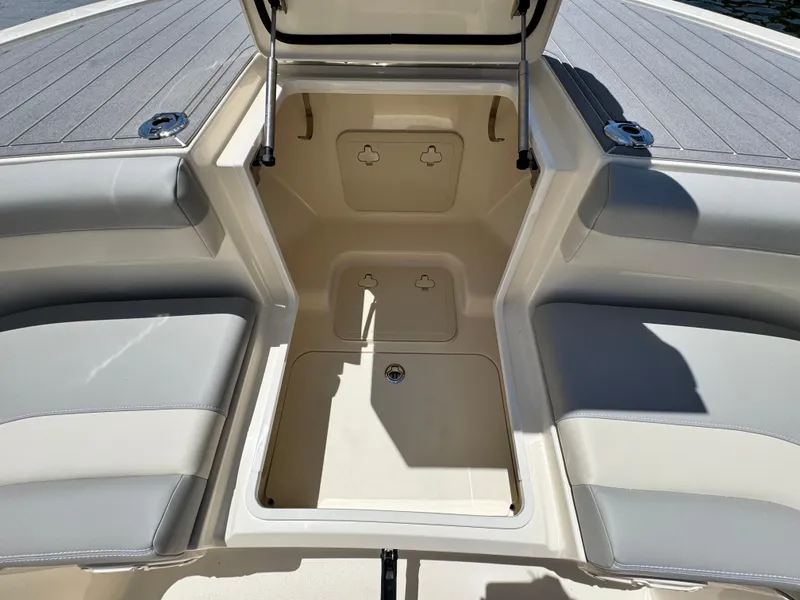 Slide: The Image of 2025 Scout 281 XSS boat interior with open storage compartment and cushioned seating. - 27