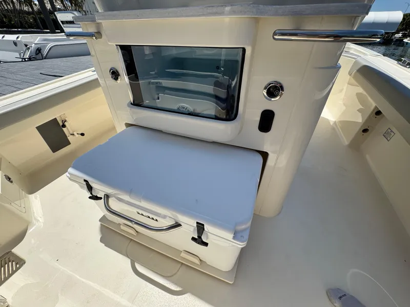 Slide: The Image of 2025 Scout 281 XSS boat interior with storage compartment and cooler. - 9
