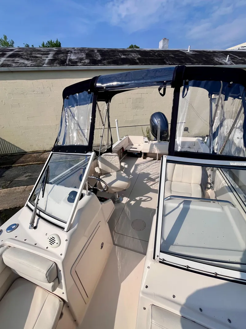 Slide: The Image of 2017 Grady-White Freedom 192 boat with clear canopy and seating, docked outdoors. - 13