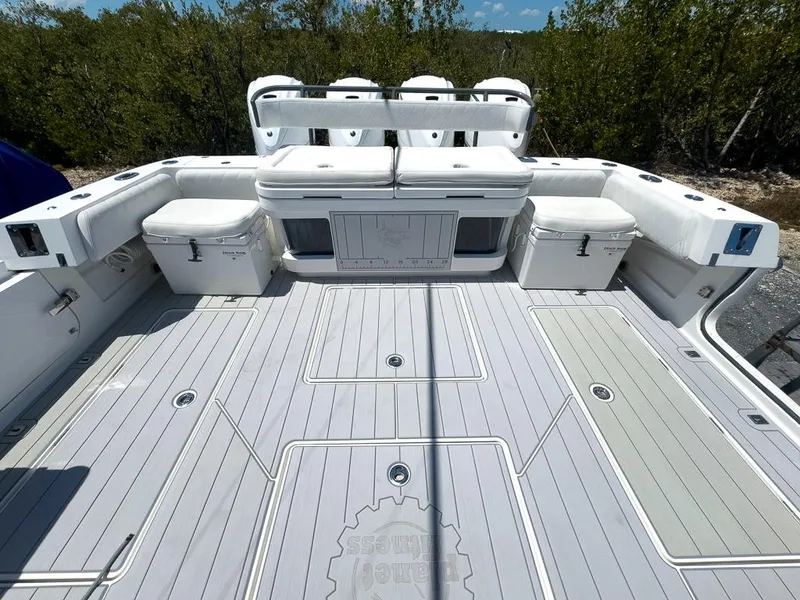 Slide: The Image of 2019 HCB 53 Sueños boat deck with seating and storage, surrounded by lush greenery. - 10