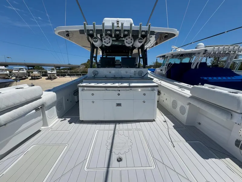 Slide: The Image of 2019 HCB 53 Sueños boat deck with seating and storage under clear blue sky. - 11