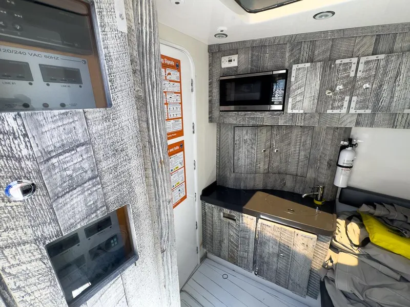 Slide: The Image of Interior of 2019 HCB 53 Sueños boat with modern kitchenette and wood paneling. - 24