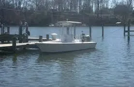 Slide: The Image of A 1999 Custom pump out boat docked on a calm river. - 3