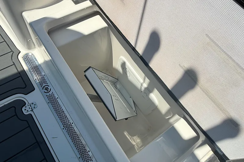 Slide: The Image of 2021 Sea Pro 248 Bay boat storage compartment with open lid, showing interior details. - 13