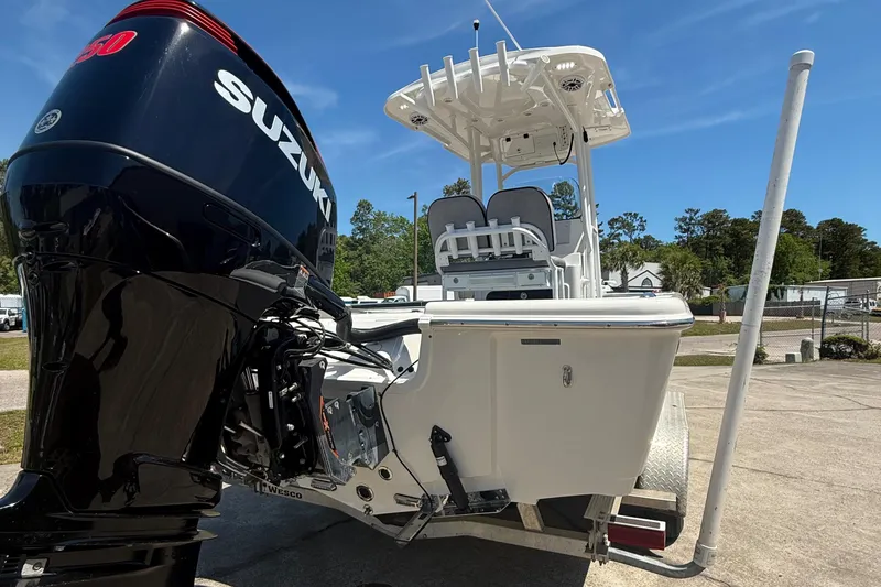 Slide: The Image of 2021 Sea Pro 248 Bay boat with Suzuki engine, parked outdoors on a sunny day. - 2