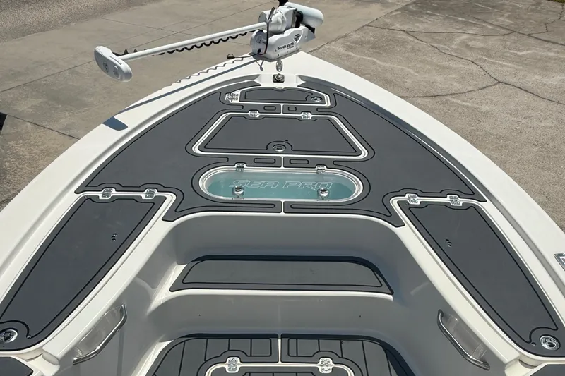 Slide: The Image of 2021 Sea Pro 248 Bay boat deck with trolling motor, featuring sleek design and storage compartments. - 4
